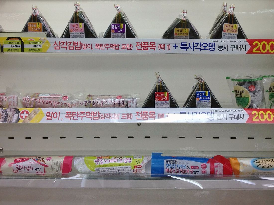 편의점 진열대에 삼각김밥과 김밥이 줄지어 놓인 모습